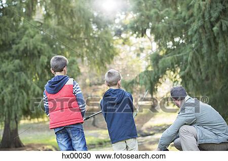 Stock Image - Father and sons fishing in woods. Fotosearch