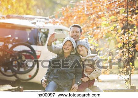 Father and sons taking selfie in autumn park View Large Photo Image Stock Photo - Father and sons taking selfie in autumn park. Fotosearch