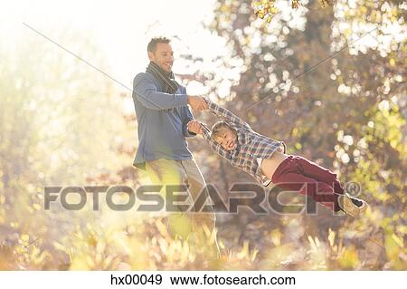 Father spinning son among autumn leaves View Large Photo Image Stock Photo - Father spinning son among autumn leaves. Fotosearch