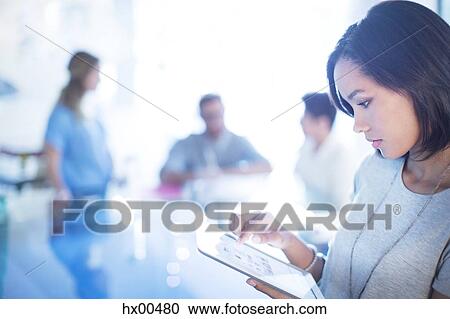 Stock Image - Focused businesswoman using digital tablet. Fotosearch