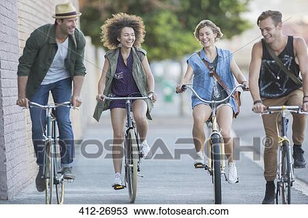 Friends riding bicycles on urban sidewalk View Large Photo Image Stock Image - Friends riding bicycles on urban sidewalk. Fotosearch