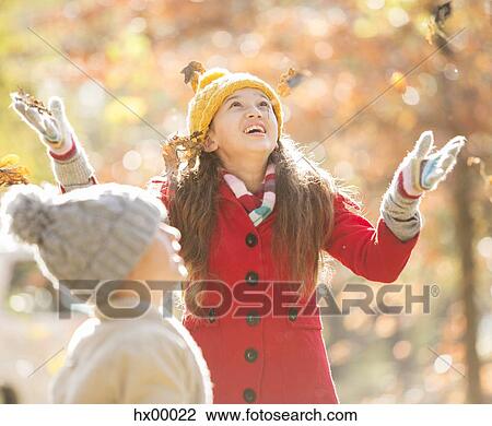 Girl throwing autumn leaves View Large Photo Image Stock Image - Girl throwing autumn leaves. Fotosearch
