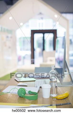 Headphones, water bottle, coffee and banana on desk with computer View Large Photo Image Stock Image - Headphones, water bottle, coffee and banana on desk with computer. Fotosearch