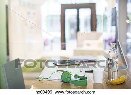 Headphones, water bottle, coffee and banana on desk with computer View Large Photo Image Stock Photo - Headphones, water bottle, coffee and banana on desk with computer. Fotosearch