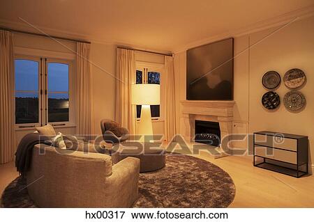 Stock Photo - Illuminated floor lamp in living room with fireplace. Fotosearch