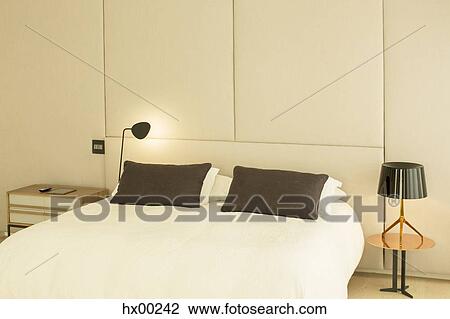 Stock Image - Illuminated lamp at bedside. Fotosearch