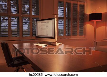 Illuminated lamp behind computer on desk in home office View Large Photo Image Stock Photography - Illuminated lamp behind computer on desk in home office. Fotosearch