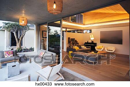 Stock Image - Illuminated living room open to patio. Fotosearch