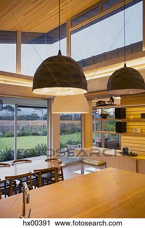 Illuminated modern pendants hanging over wood kitchen island View Large Photo Image Stock Image - Illuminated modern pendants hanging over wood kitchen island. Fotosearch