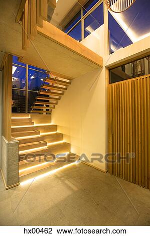 Stock Image - Illuminated modern stairs off foyer in luxury house. Fotosearch