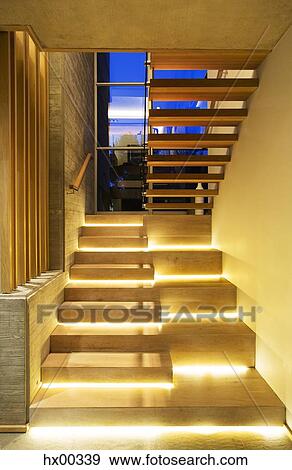 Stock Photo - Illuminated modern wood stairs in luxury house. Fotosearch