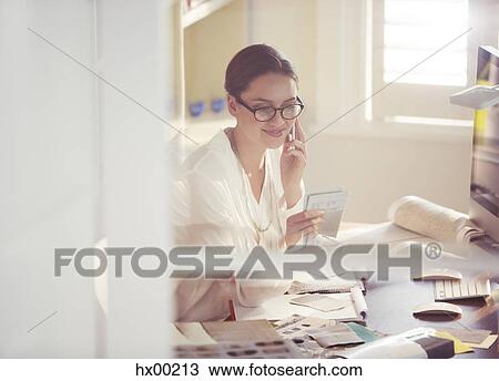 Interior designer examining fabric swatches and talking on cell phone in office View Large Photo Image Stock Image - Interior designer examining fabric swatches and talking on cell phone in office. Fotosearch