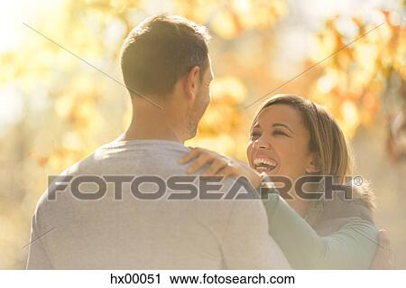Laughing couple face to face outdoors View Large Photo Image Stock Image - Laughing couple face to face outdoors. Fotosearch