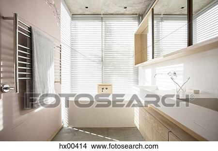 Light shining through blinds behind soaking tub in luxury bathroom View Large Photo Image Picture - Light shining through blinds behind soaking tub in luxury bathroom. Fotosearch