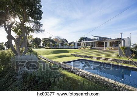 Stock Photo - Luxury modern house, yard and swimming pool. Fotosearch
