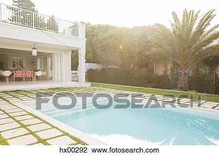 Stock Image - Luxury swimming pool surrounded by paver stones. Fotosearch