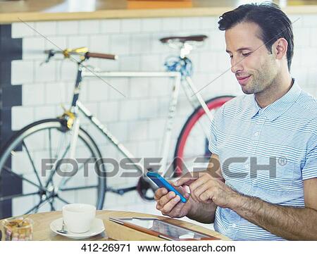 Man texting with cell phone near bicycle in cafe View Large Photo Image Stock Image - Man texting with cell phone near bicycle in cafe. Fotosearch