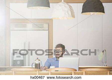 Man writing at laptop in kitchen with French press coffee View Large Photo Image Stock Photo - Man writing at laptop in kitchen with French press coffee. Fotosearch