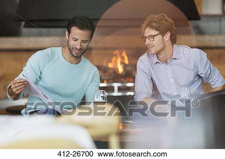 Men drinking red wine and reading brochure View Large Photo Image Stock Image - Men drinking red wine and reading brochure. Fotosearch