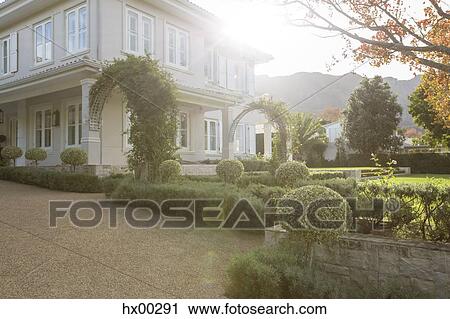 Stock Image - Ornamental garden and luxury house. Fotosearch