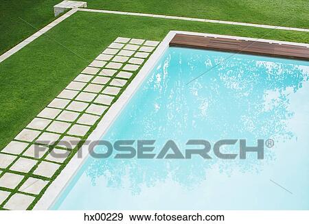 Stock Photo - Paving stones in a row along swimming pool in backyard. Fotosearch