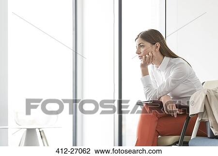 Pensive brunette businesswoman looking out office window with hand on chin View Large Photo Image Stock Image - Pensive brunette businesswoman looking out office window with hand on chin. Fotosearch