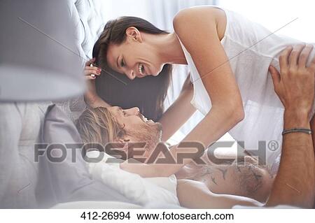 Playful couple on bed View Large Photo Image Picture - Playful couple on bed. Fotosearch