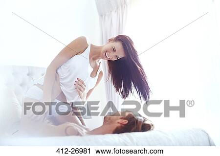 Playful couple on bed View Large Photo Image Stock Image - Playful couple on bed. Fotosearch