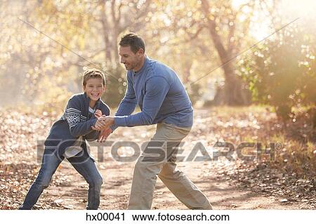 Playful father and son on path in woods View Large Photo Image Stock Image - Playful father and son on path in woods. Fotosearch