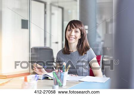 Portrait confident brunette businesswoman working in conference room View Large Photo Image Stock Photo - Portrait confident brunette businesswoman working in conference room. Fotosearch