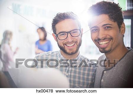 Stock Photo - Portrait confident businessmen reviewing paperwork. Fotosearch