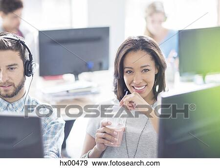 Portrait confident businesswoman drinking smoothie in office View Large Photo Image Stock Photo - Portrait confident businesswoman drinking smoothie in office. Fotosearch