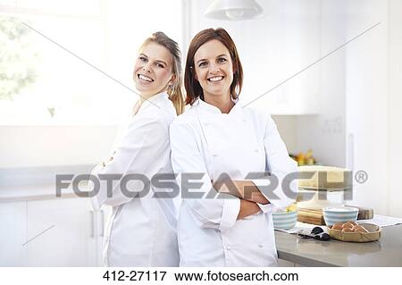 Portrait confident chefs back to back in kitchen View Large Photo Image Stock Photo - Portrait confident chefs back to back in kitchen. Fotosearch