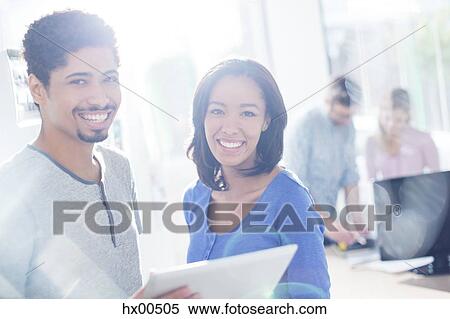 Stock Photography - Portrait confident creative business people using digital tablet. Fotosearch