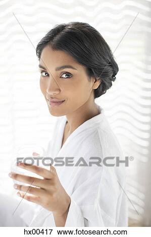 Stock Photo - Portrait confident woman in bathrobe drinking water. Fotosearch