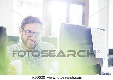 Portrait enthusiastic creative businessman drinking coffee at computer View Large Photo Image Stock Image - Portrait enthusiastic creative businessman drinking coffee at computer. Fotosearch