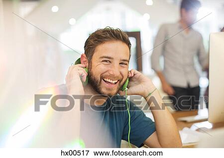 Portrait enthusiastic creative businessman listening to headphones in office View Large Photo Image Stock Photo - Portrait enthusiastic creative businessman listening to headphones in office. Fotosearch