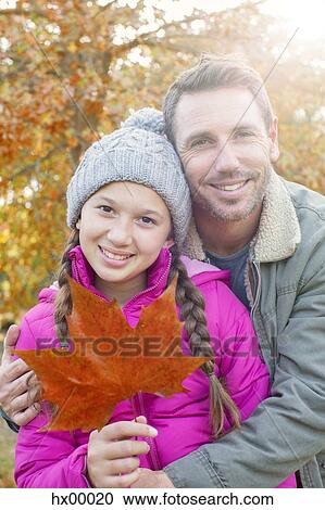 Portrait father and daughter with autumn leaf hugging View Large Photo Image Stock Image - Portrait father and daughter with autumn leaf hugging. Fotosearch