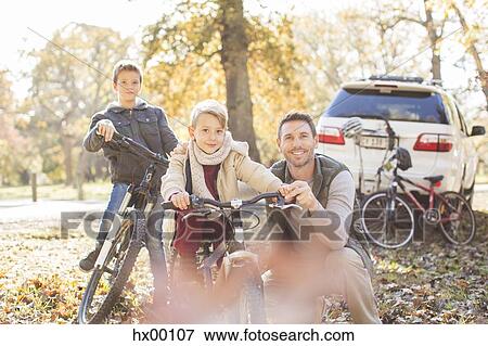Portrait father and sons with bicycles in autumn park View Large Photo Image Stock Photo - Portrait father and sons with bicycles in autumn park. Fotosearch