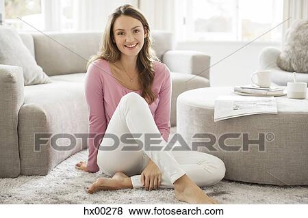 Stock Photo - Portrait smiling barefoot woman in living room. Fotosearch