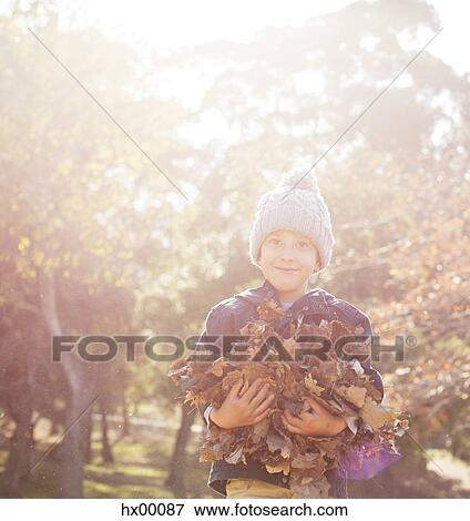 Portrait smiling boy holding bunch of autumn leaves View Large Photo Image Stock Photo - Portrait smiling boy holding bunch of autumn leaves. Fotosearch