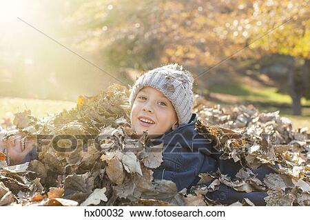 Portrait smiling boys covered in autumn leaves View Large Photo Image Stock Image - Portrait smiling boys covered in autumn leaves. Fotosearch