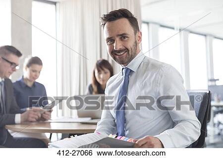 Portrait smiling brunette businessman with report in conference room meeting View Large Photo Image Stock Photograph - Portrait smiling brunette businessman with report in conference room meeting. Fotosearch