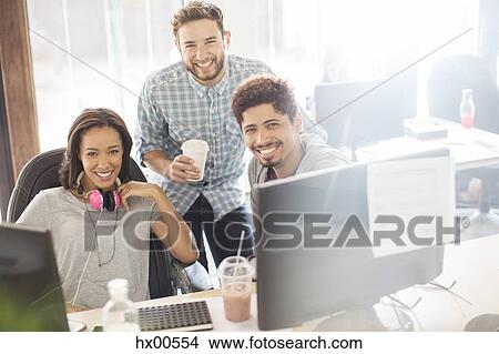 Picture - Portrait smiling creative business people with coffee and headphones in office. Fotosearch