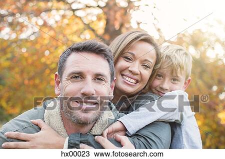Portrait smiling family hugging in front of autumn leaves View Large Photo Image Stock Image - Portrait smiling family hugging in front of autumn leaves. Fotosearch