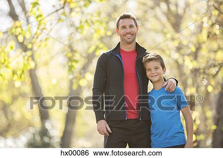 Portrait smiling father and son hugging outdoors View Large Photo Image Stock Photograph - Portrait smiling father and son hugging outdoors. Fotosearch