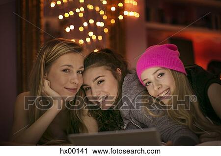 Stock Image - Portrait smiling teenage girls using digital tablet. Fotosearch