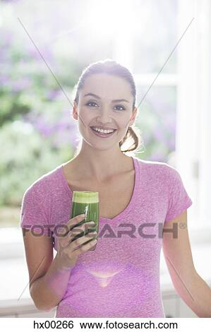 Stock Photograph - Portrait smiling woman drinking green smoothie. Fotosearch
