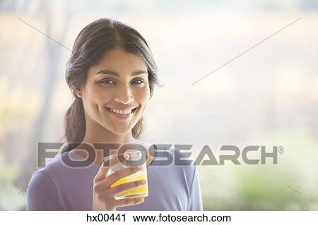 Portrait smiling woman drinking orange juice View Large Photo Image Stock Image - Portrait smiling woman drinking orange juice. Fotosearch