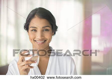 Stock Image - Portrait smiling woman drinking water. Fotosearch